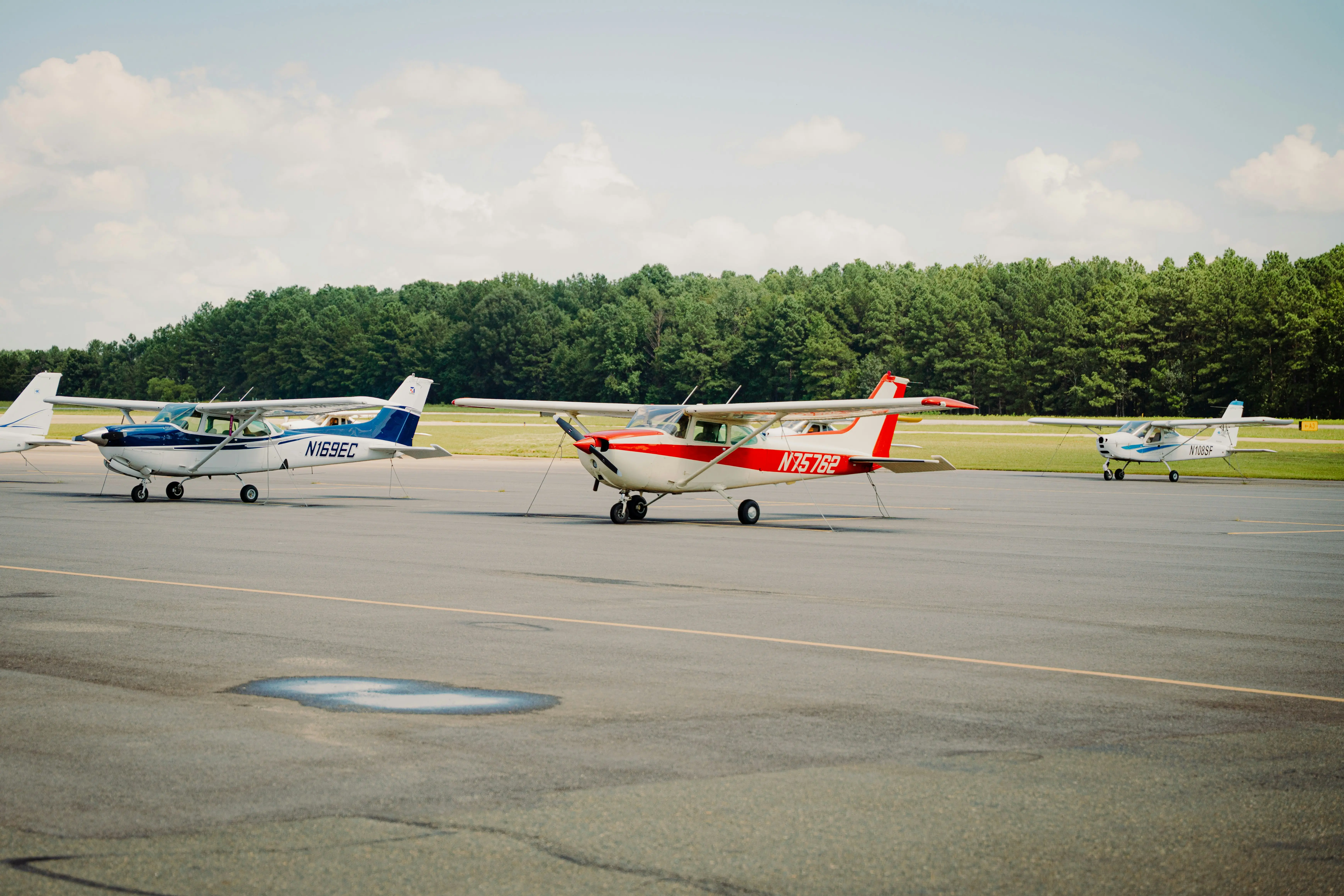 Two small airplanes parked on a runway